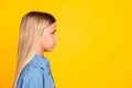 Side profile photo of pretty serious calm little girl wearing denim shirt looking on blank space isolated on vivid