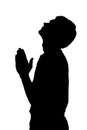 Side profile portrait silhouette of religious teenage boy praying with raised head