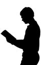 Side profile portrait silhouette of standing teenage boy reading