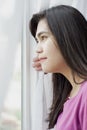 Side profile of teen girl looking out window