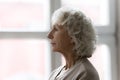 Side profile view face of elderly serious grey haired woman