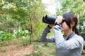 The side profile of Woman looking though binocular