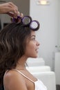 Side profile of young woman wearing curlers