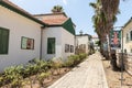 Side quiet street with stone pavement and with white painted houses in Zikhron Yaakov city in northern Israel