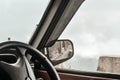 Side rear-view mirror on a car on a countryside road. Royalty Free Stock Photo