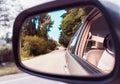 Side rear-view mirror on a car. Reflection of road at the car side mirror. Look in the rear view mirror of a vehicle Royalty Free Stock Photo