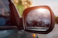 Side rear-view mirror on a modern car. Rainy water drops on glass Royalty Free Stock Photo