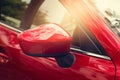 Side rear-view mirror red car on street Royalty Free Stock Photo