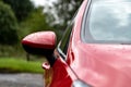 The side rear-view mirror of the red modern aerodynamic car with small depth of field andwater drops Royalty Free Stock Photo