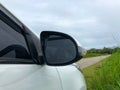 Side rear-view mirror white car on a rural road on cloudy day ready for travel Royalty Free Stock Photo