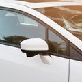 Side rear-view mirror on a white modern car. Square crop Royalty Free Stock Photo