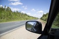 Side rearview mirror. The car is on the highway.Travel by car