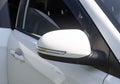 side rearview mirror of a white car with duplicate turning elements