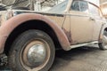 Side rusty abandoned forgotten antique oldtimer old car and motorcycles at junkyard factory storage warehouse indoors