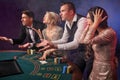 Group of a stylish rich friends are playing poker at casino. Royalty Free Stock Photo