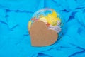 Side shot of a glove hemisphere with heart-shaped paper on the colored paper ground.