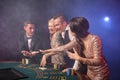 Group of a stylish rich friends are playing poker at casino. Royalty Free Stock Photo