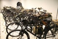 Side shot of a line of vintage old bicycles with guns parling on a display