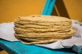 Side shot of Stack of fresh corn tortillas on paper - close up