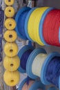Side shot of the strings wrapped around the spool. Ropes in white, blue, red, yellow colors. Shipping and ropes used in industry