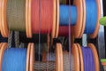 Side shot of the strings wrapped around the spool. Ropes in white, blue, red, yellow colors. Shipping and ropes used in industry