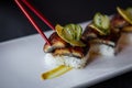 Side Shot of Sushi Picked Up With Red Chopsticks. Royalty Free Stock Photo