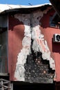 Side of suburban family house damaged after devastating fire with visible insulation over burned charred building blocks