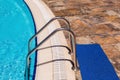 Side of a swimming pool with chrome stairs Royalty Free Stock Photo