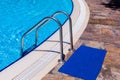 Side of a swimming pool with chrome stairs Royalty Free Stock Photo