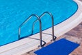 Side of a swimming pool with chrome stairs Royalty Free Stock Photo