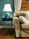 Side table with blue table lamp near the sofa. Metal legs, black countertop