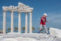 Small child jumps over the ancient roman ruins in front of the r