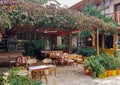 Side, Turkey, November 2019: Rustic outdoor cafe, with wooden tables and chairs, wrapped in wild grapes and next to the sea. No Royalty Free Stock Photo