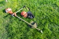 Side up view at handheld gasoline lawn mower, safety helmet with eye and hearing protection, padded shoulder straps left after Royalty Free Stock Photo