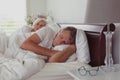Active senior couple sleeping together in bed in bedroom at comfortable home Royalty Free Stock Photo