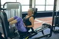 Active senior woman exercising with leg press machine in fitness studio Royalty Free Stock Photo