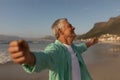 Senior man standing with arms outstretched on the beach Royalty Free Stock Photo