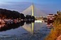 Side view of Ada bridge at night with reflection over Belgrade marina on Sava river Royalty Free Stock Photo