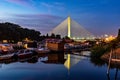 Side view of Ada bridge at night with reflection over Belgrade marina on Sava river Royalty Free Stock Photo