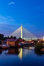 Side view of Ada bridge at night with reflection over Belgrade marina on Sava river Royalty Free Stock Photo