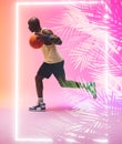 Side view of african american basketball player dribbling ball and running by rectangle and plants Royalty Free Stock Photo