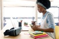 Female graphic designer using graphics tablet while looking at laptop at desk Royalty Free Stock Photo