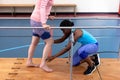 Female physiotherapist assisting disabled senior woman walk with parallel bars in sports center Royalty Free Stock Photo