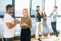 Side view of African American male posing with young woman colleague looking at camera, selective focus. Royalty Free Stock Photo