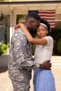 Side view of african american soldier husband embracing wife after returning home from army Royalty Free Stock Photo