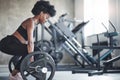 Side view. African american woman with curly hair and in sportive clothes have fitness day in the gym Royalty Free Stock Photo