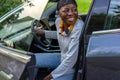 Happy African woman sitting in electric car with open door. Royalty Free Stock Photo