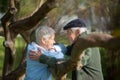 Side view of aged couple resting under trees Royalty Free Stock Photo