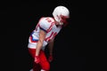 Side view of American football player wearing helmet taking position while playing against black background Royalty Free Stock Photo