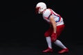 Side view of American football player wearing helmet taking position while playing against black background Royalty Free Stock Photo